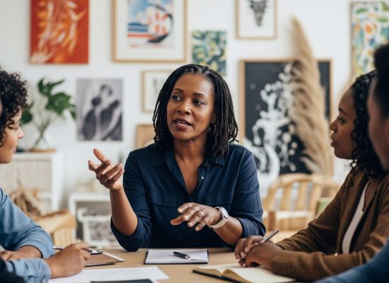 Black woman leading team meeting in creative coworking space